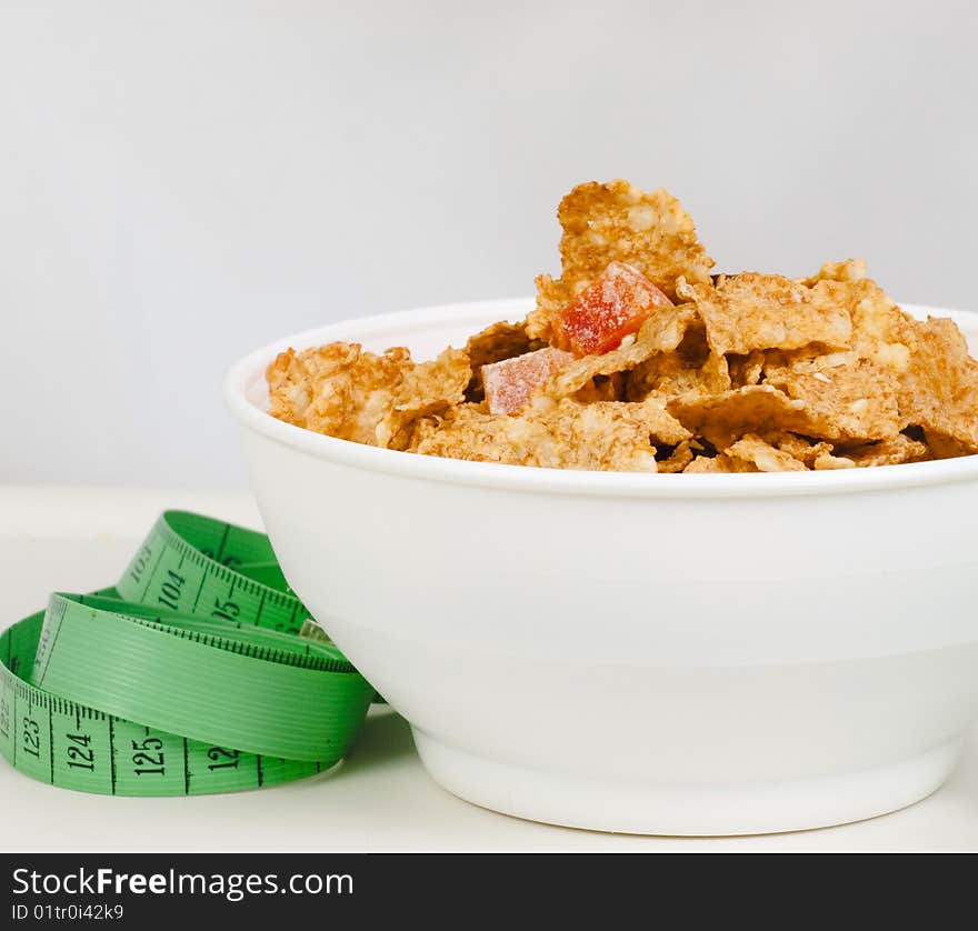 Measurement tape wrapped around dish with flakes/Concept for health, diet