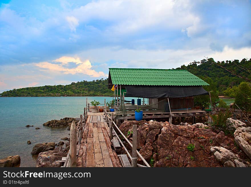 Hut and footbridge on rocky coastline