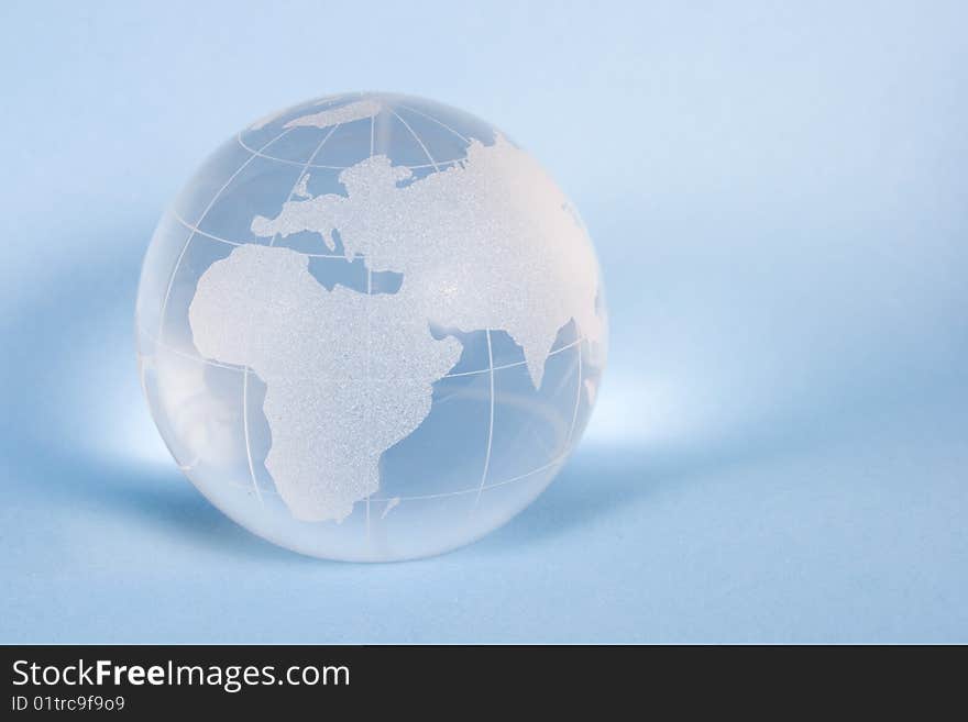 World from glass on blue background