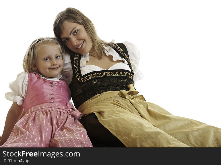 Bavarian Mother and Daughter are sitting on the floor dressed with typical Oktoberfest Dirndl. Bavarian Mother and Daughter are sitting on the floor dressed with typical Oktoberfest Dirndl