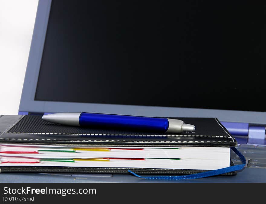 Close up of a calendar and a pen on a computer. Close up of a calendar and a pen on a computer