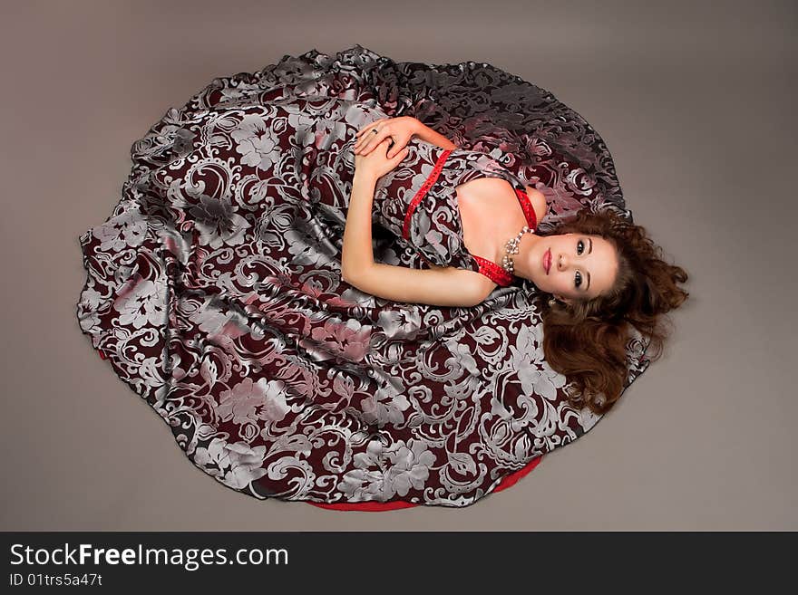 Girl with open eyes laying on floor isolated