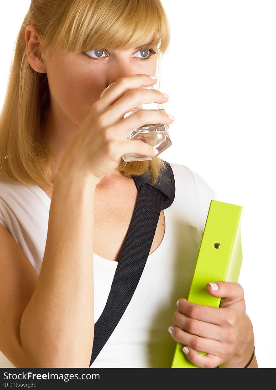 The young student drinks water from a glass on a white background. The young student drinks water from a glass on a white background