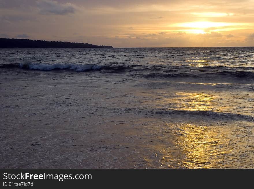 Sunset in Jimbaran beach, Bali Island, Indonesia. Calm, peaceful sunset at Indian Ocean.
