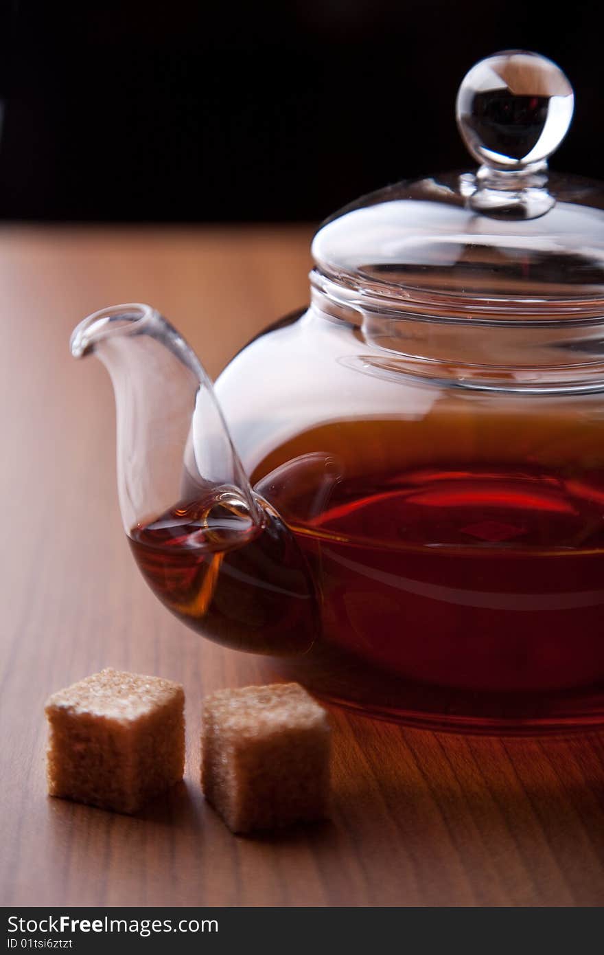 Glass teapot with black tea and sugar cubes. Glass teapot with black tea and sugar cubes