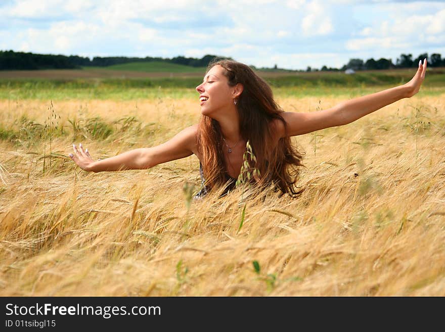 Beautiful young woman relaxing in golden field. Beautiful young woman relaxing in golden field