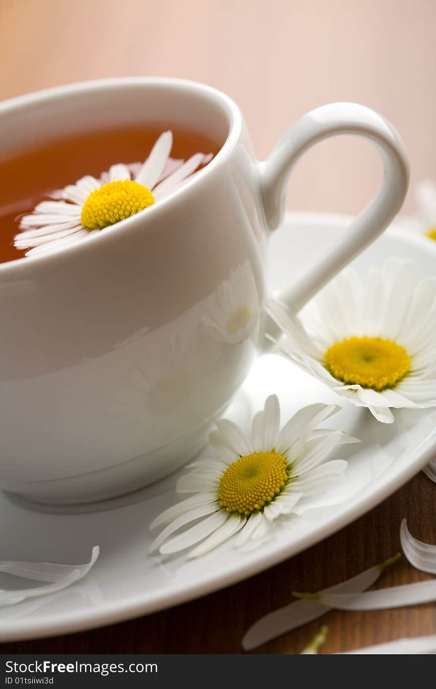 Cup of herbal tea and chamomile flowers