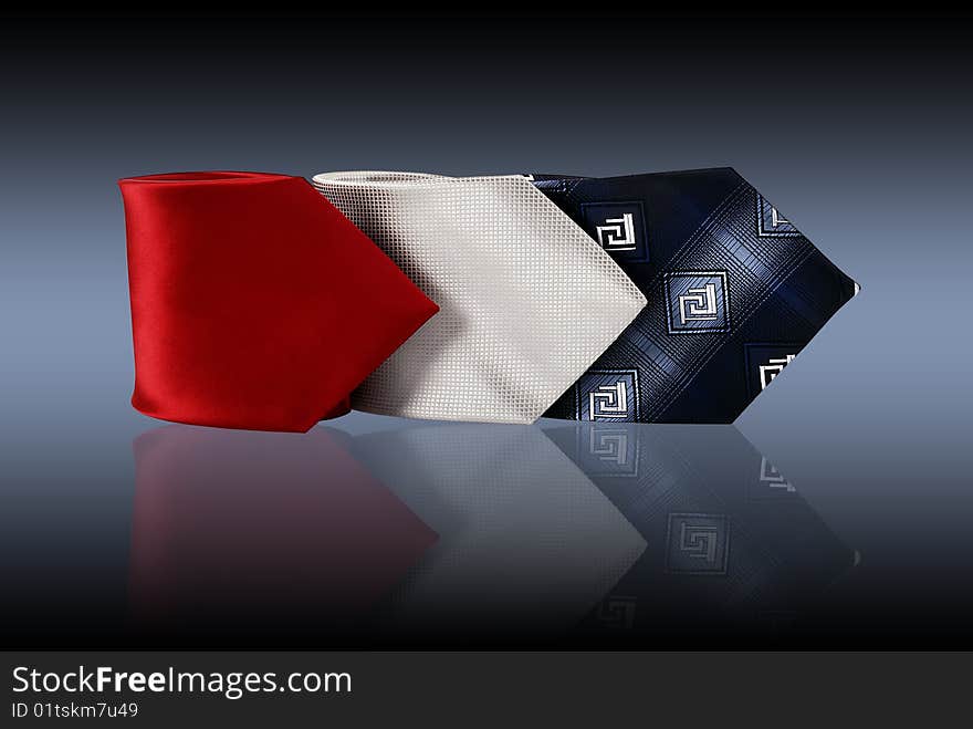 Three ties on a grey reflective background. Three ties on a grey reflective background.