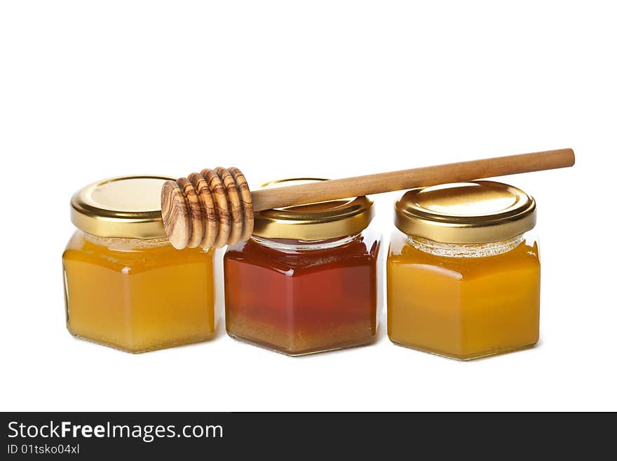 Honey In Bottles And Wooden Dipper Isolated