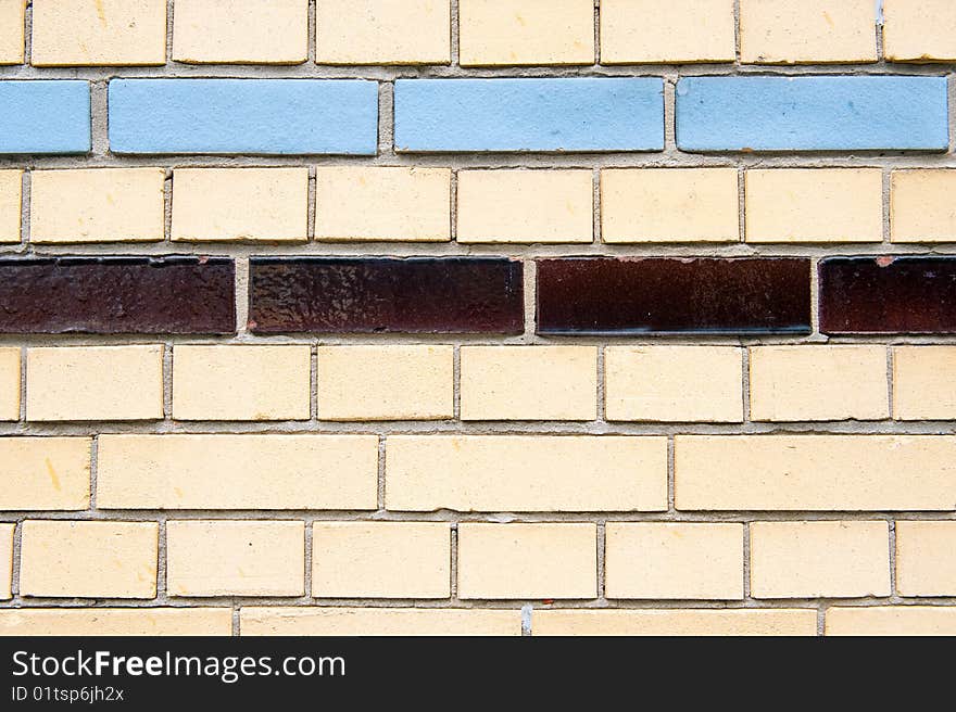 A stone wall with different colored tiles