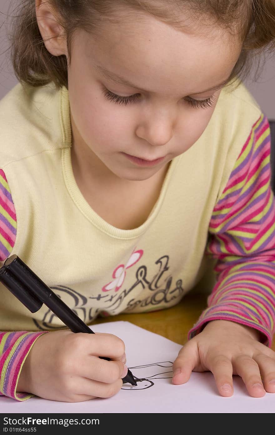 Close-up of a Girl Drawing with a black pen