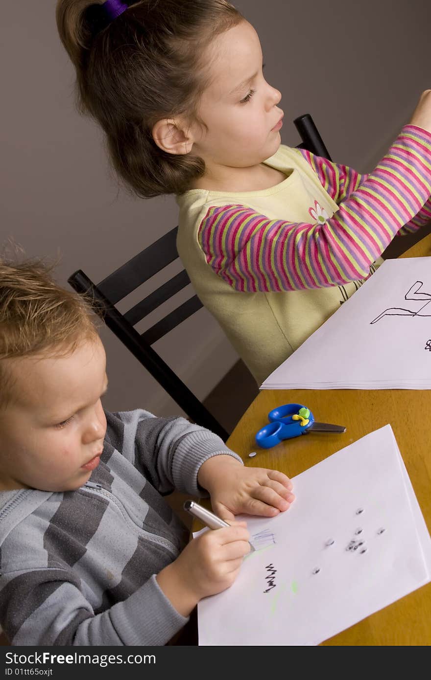 Girl and boy drawing a picture at the table. Girl and boy drawing a picture at the table