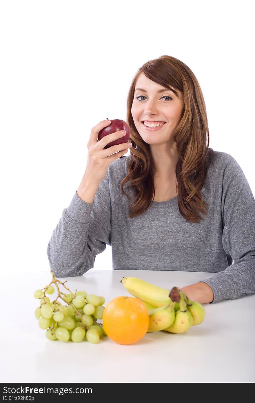 Woman eating fruit in a modern kitchen. Woman eating fruit in a modern kitchen