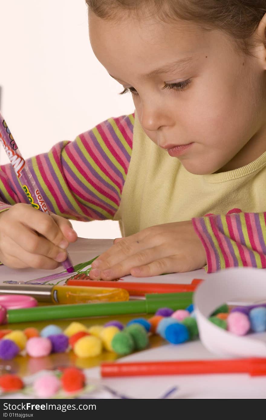 Little Girl Drawing using coloured pens with white background