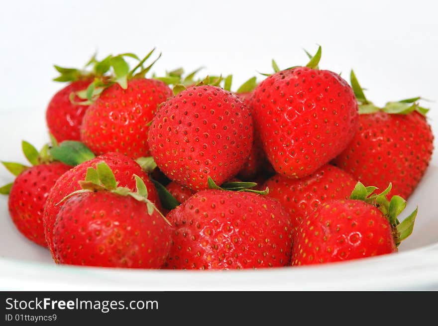 A plate of red and juicy strawberries