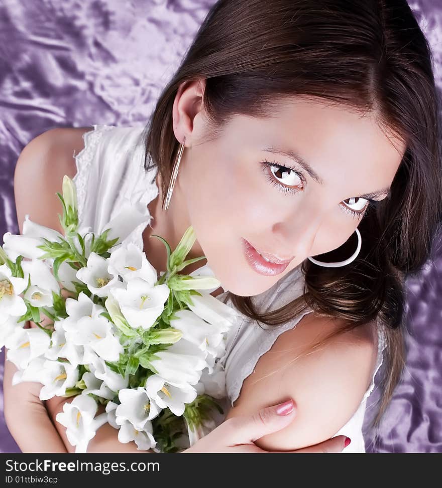 Beautiful brunette hold a bouquet white flowers