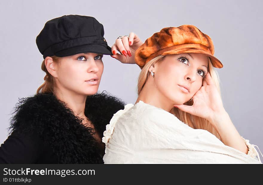 Happy beautiful young women with caps, studio shot