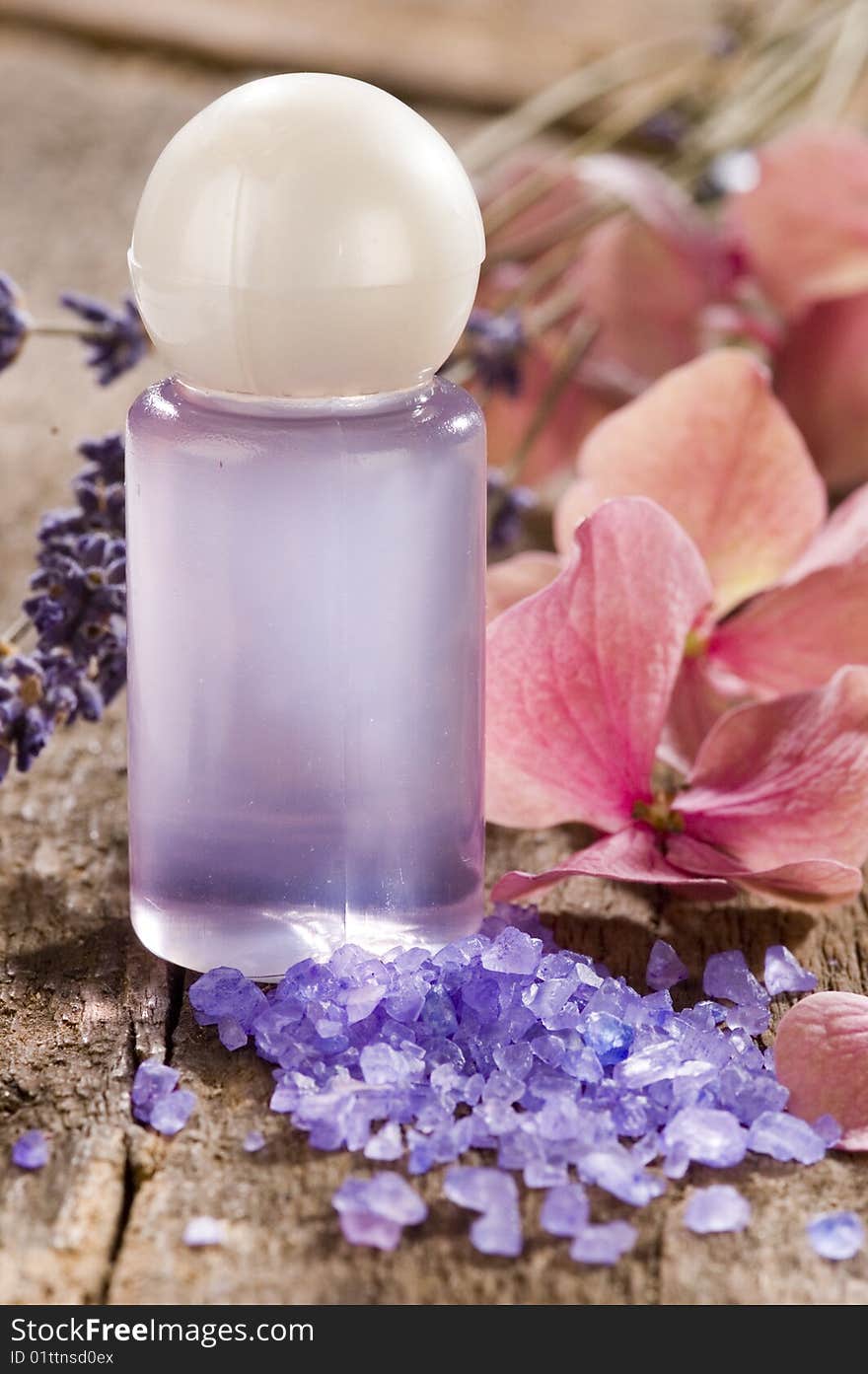 Bath salt and shower gel with flowers on a wooden table. Bath salt and shower gel with flowers on a wooden table