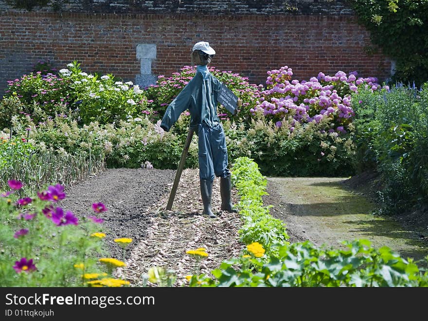 A scarecrow guards a walled potagerie (kitchen garden) at the Chateau Miromesnil near Dieppe, France where flowers mingle with vegetables. A scarecrow guards a walled potagerie (kitchen garden) at the Chateau Miromesnil near Dieppe, France where flowers mingle with vegetables.