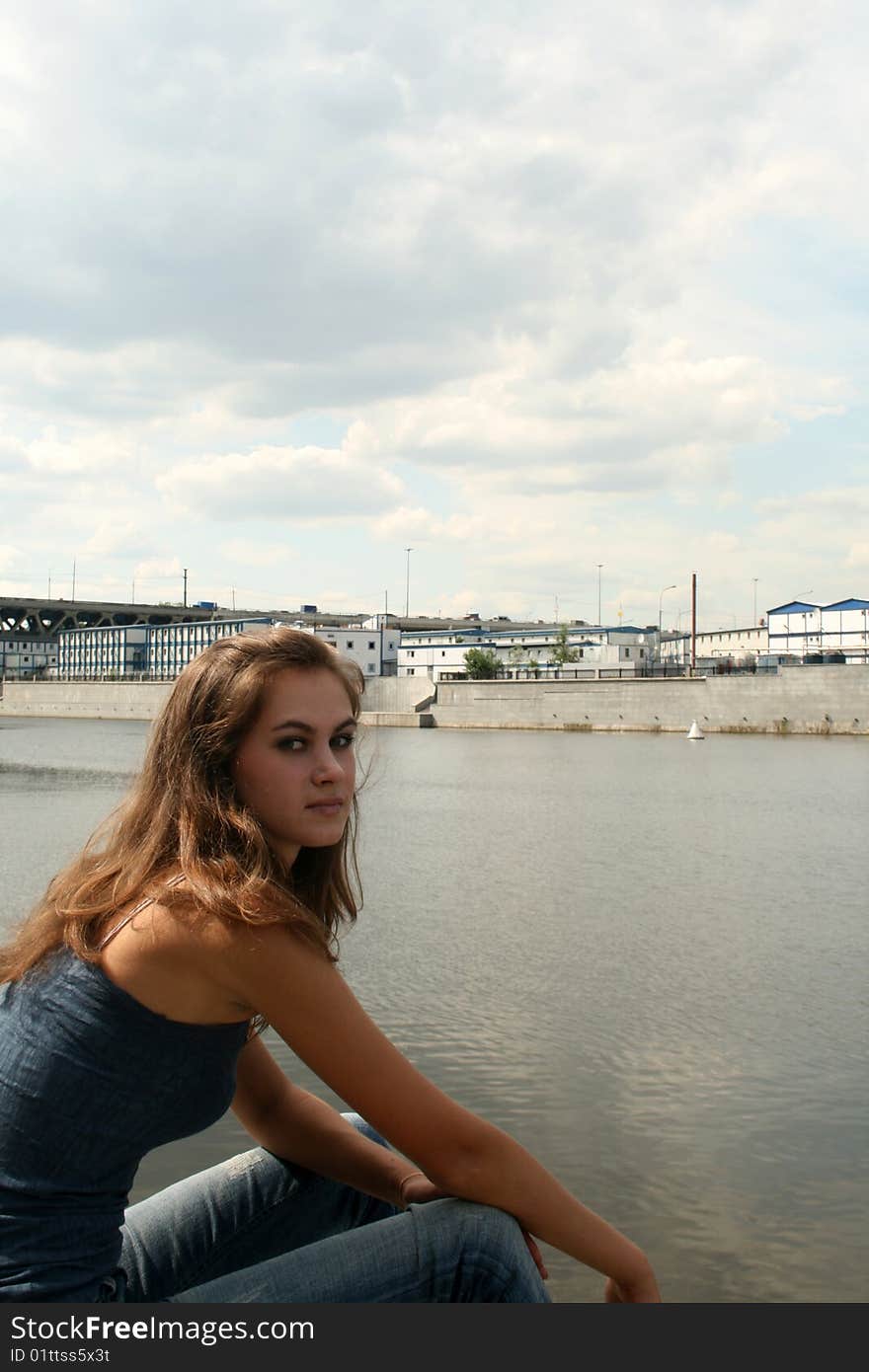 Pretty girl sitting near river