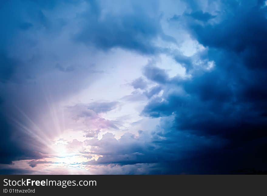 Stormy clouded sky background with sun setting