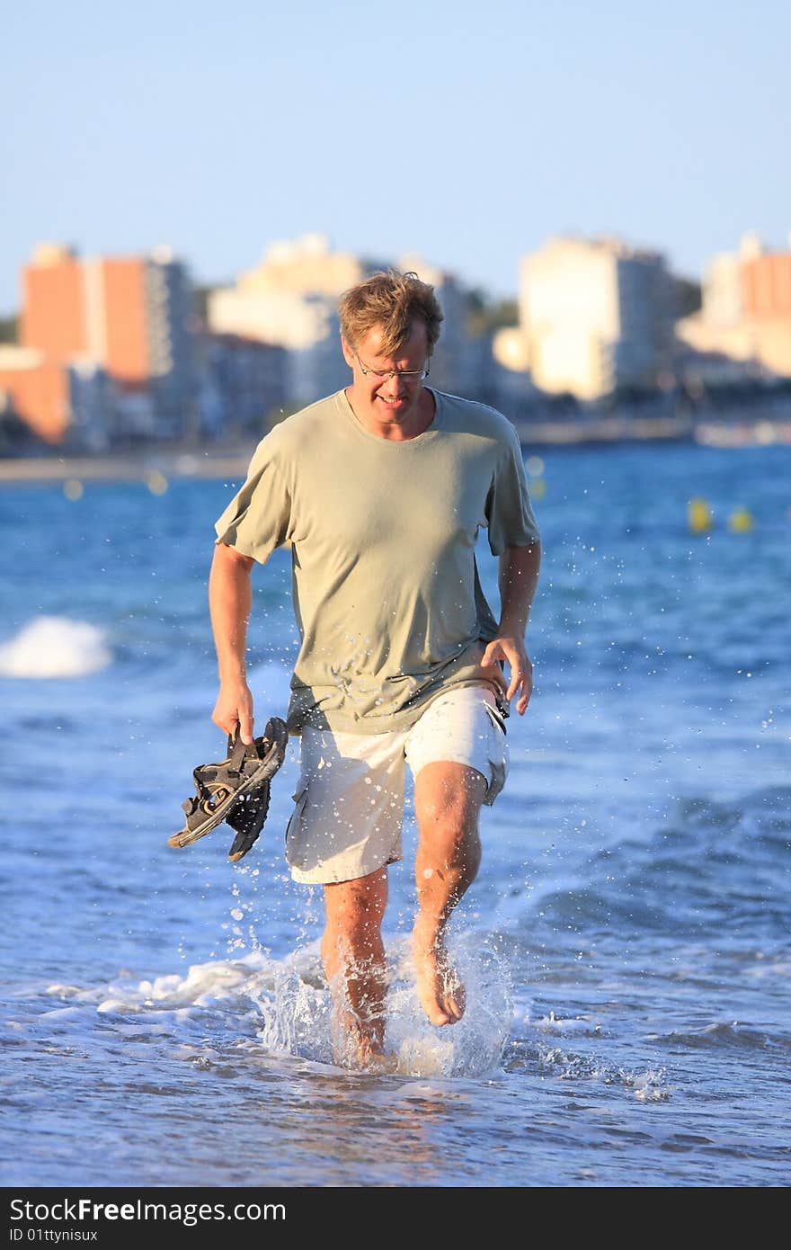 Happy young man running close to the sea