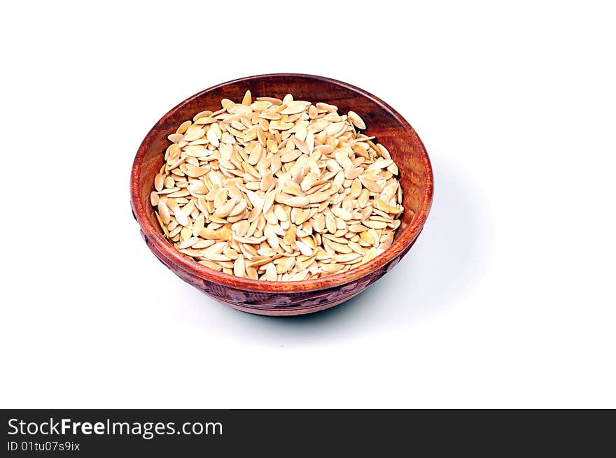 Roasted melon seeds in wooden bowl.