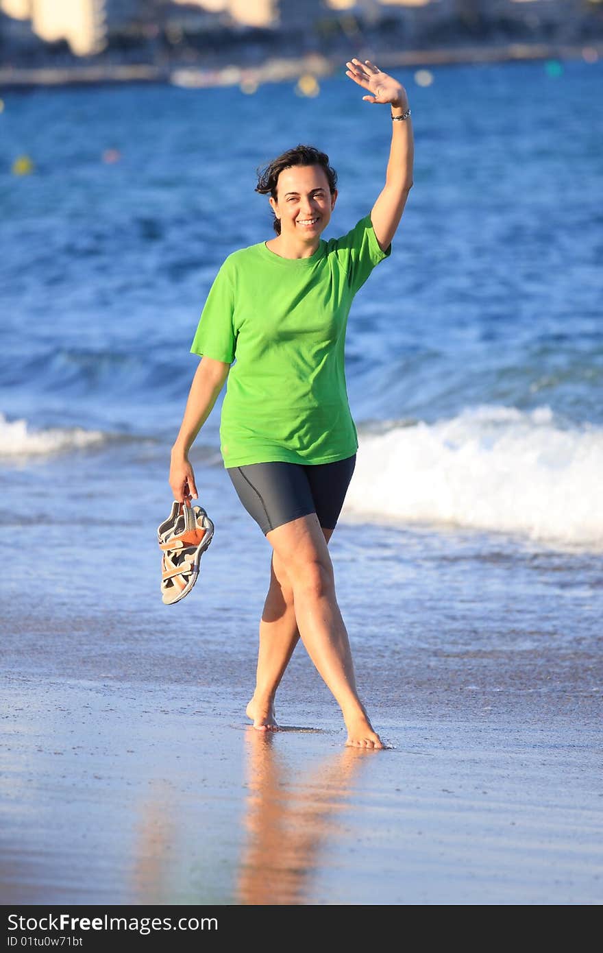 Happy woman walks close to the sea. Happy woman walks close to the sea