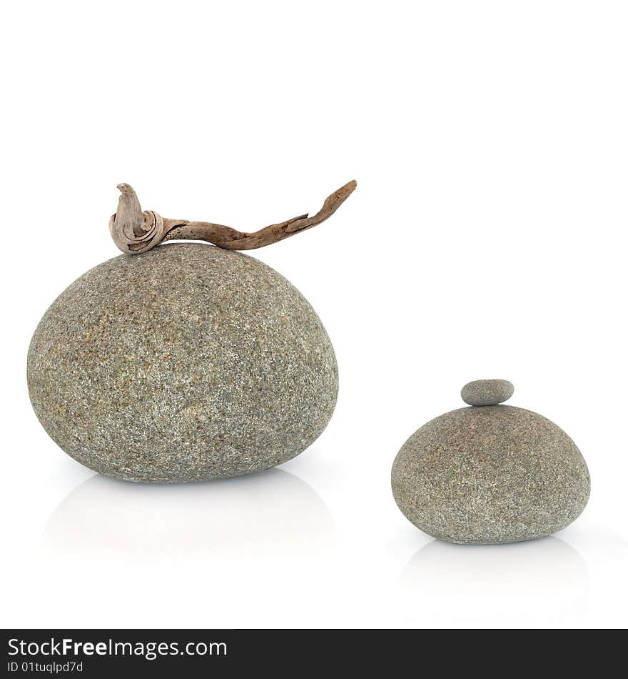 Zen abstract of two grey stones one with a piece of driftwood the other with a small stone balanced on the top, over white background. Zen abstract of two grey stones one with a piece of driftwood the other with a small stone balanced on the top, over white background.