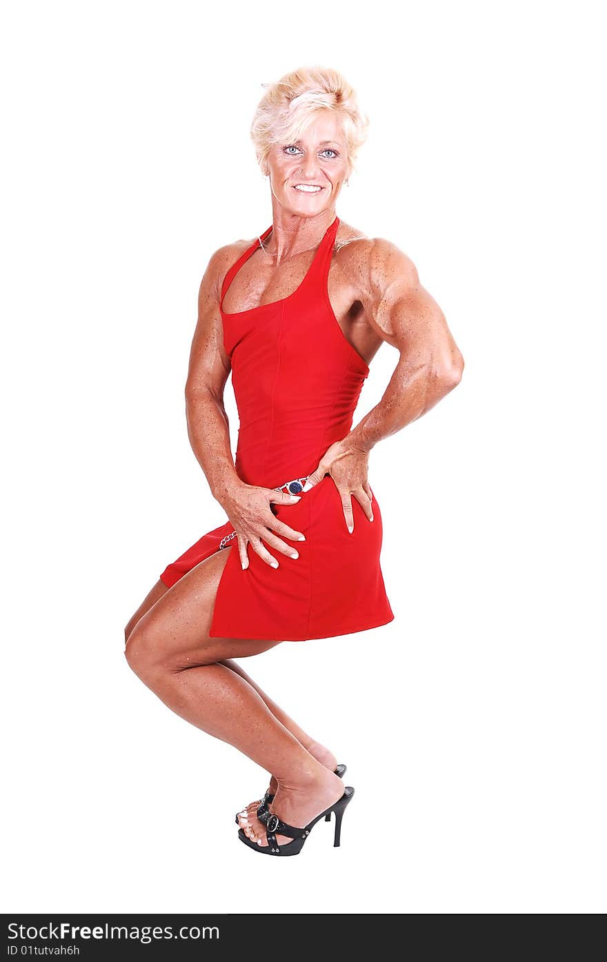 A strong blond woman in an red dress and high heels shooing her muscular body over white background. A strong blond woman in an red dress and high heels shooing her muscular body over white background.