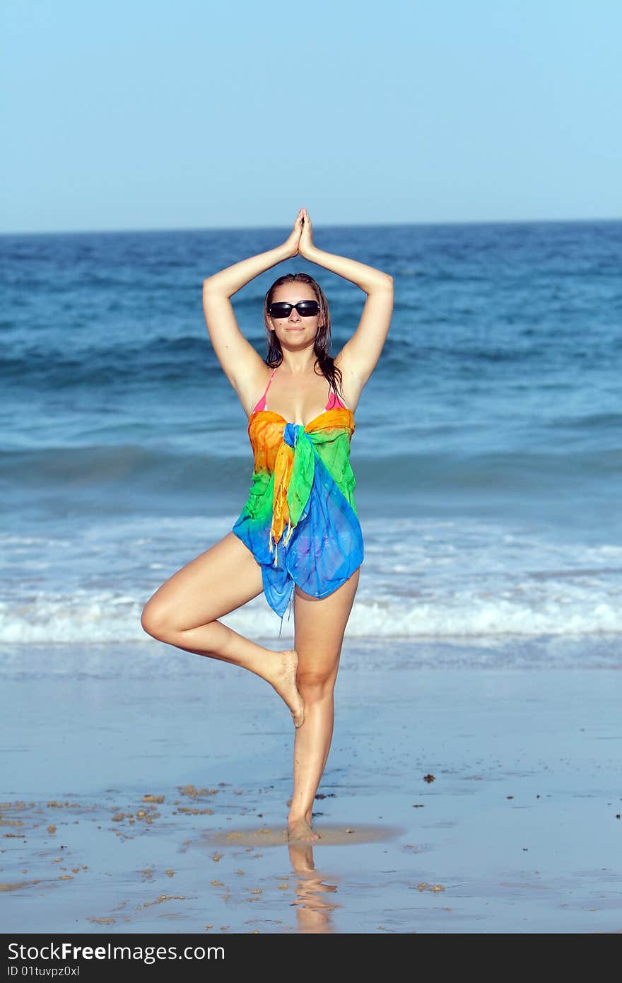 Woman doing yoga on the beach