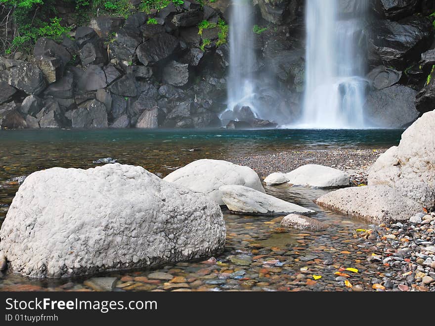 Landscape shot of majestic waterfall splashing onto rocks