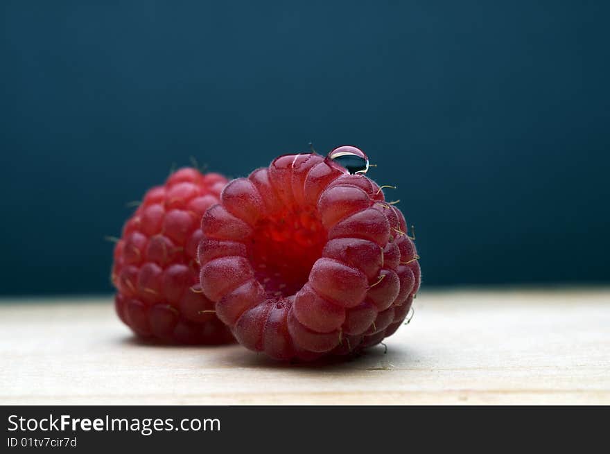 Fresh and tasty raspberries on the blue background