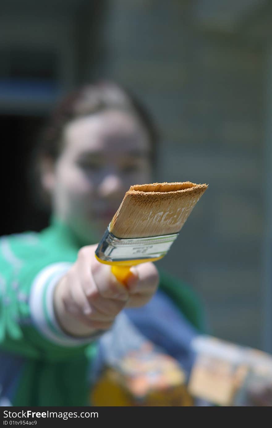 Young woman out of focus holding a brush in her hand. Young woman out of focus holding a brush in her hand