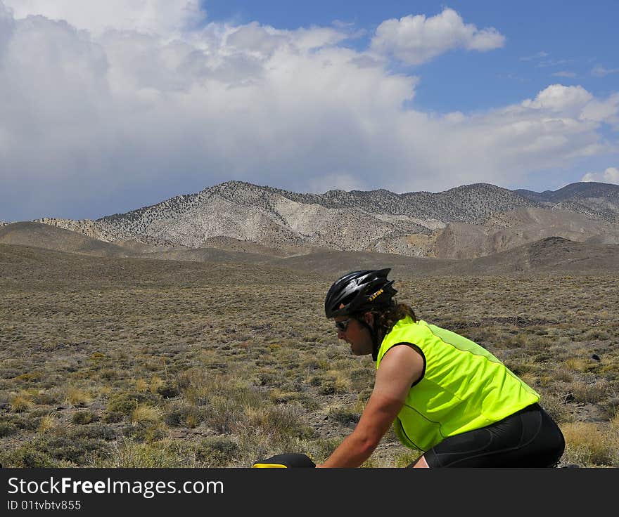 Man Cycling through Nevada Desert on Cross Country Adventure. Man Cycling through Nevada Desert on Cross Country Adventure