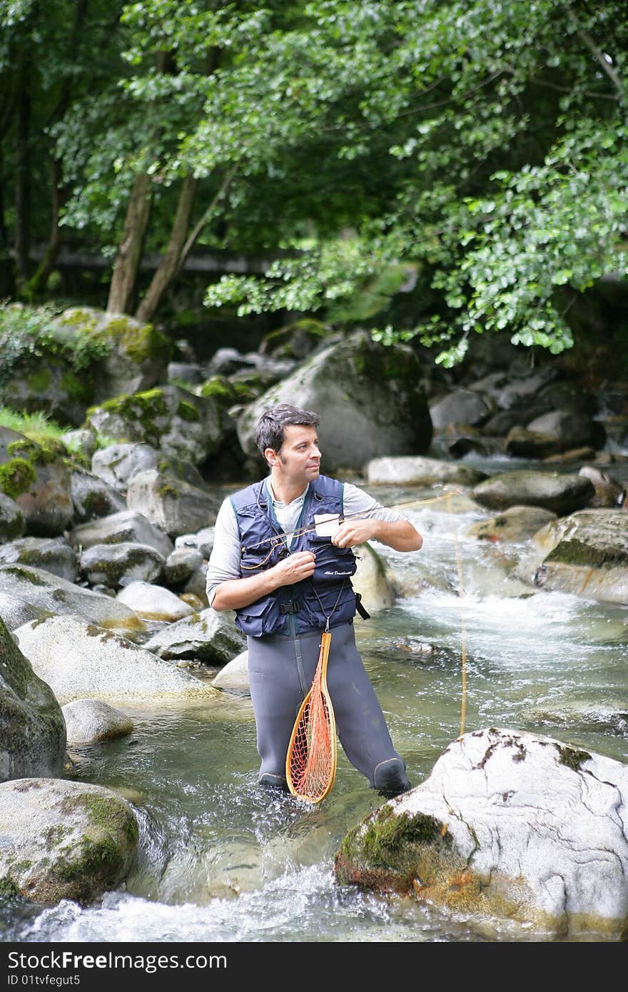 Man going fly-fishing in mountain river. Man going fly-fishing in mountain river