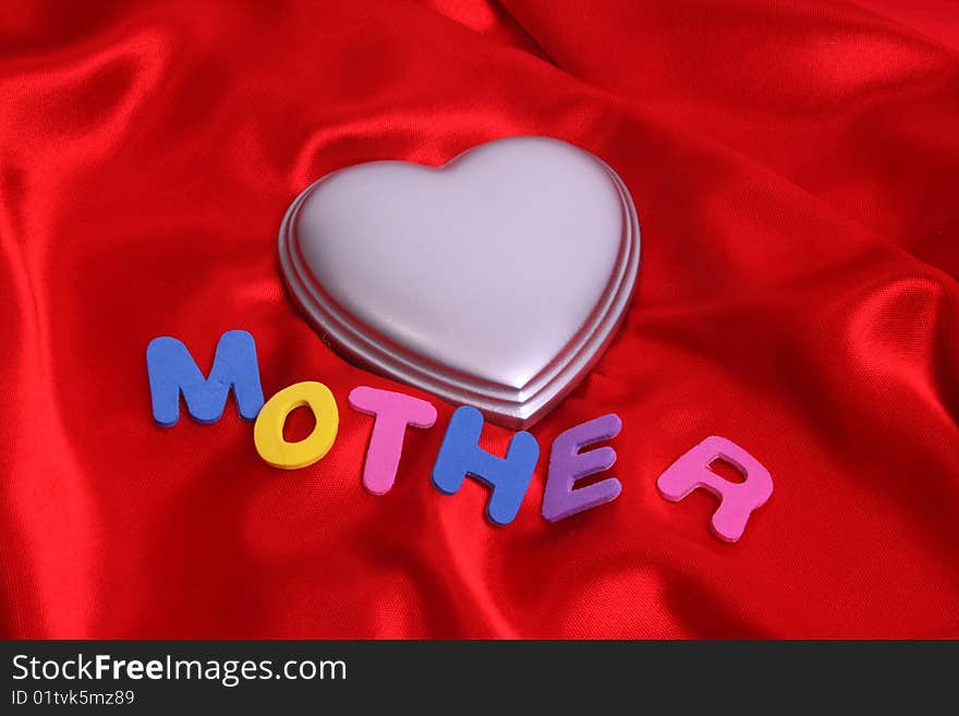 Mother and a silver heart on red satin