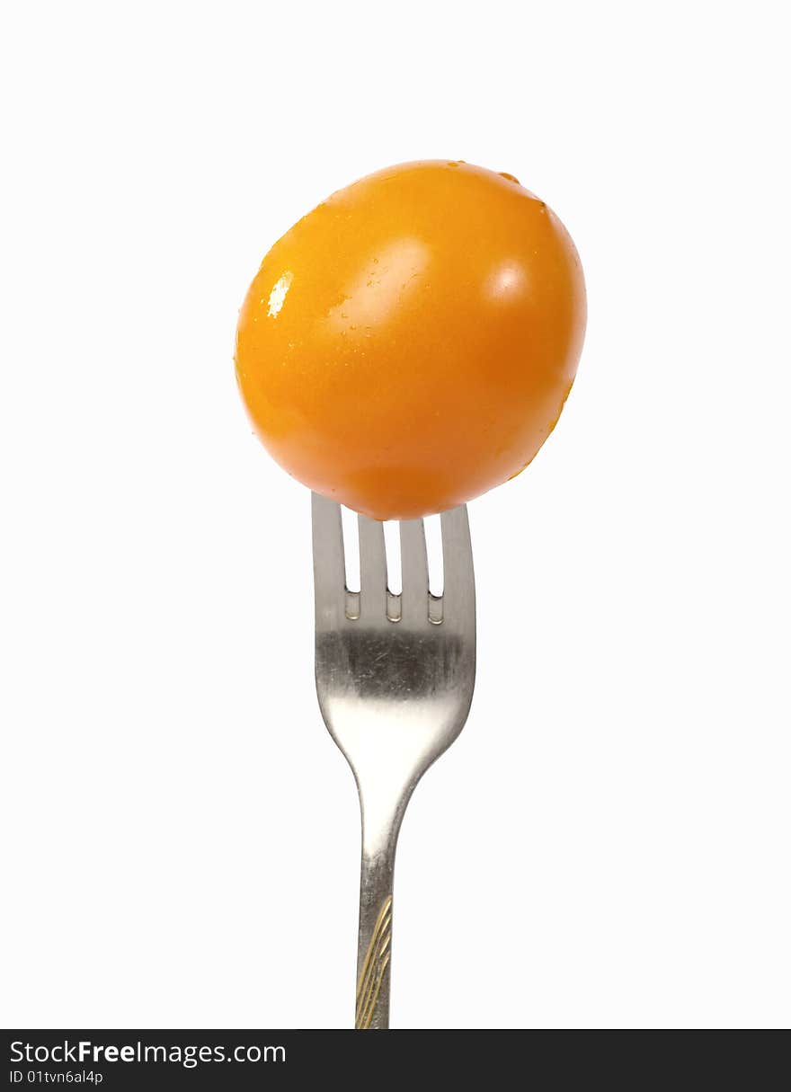 Fresh yellow tomato on the fork.