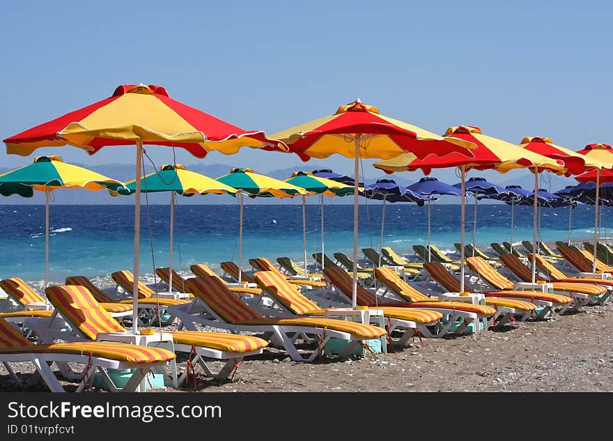 Beach with sun loungers and umbrellas near the blue sea. Beach with sun loungers and umbrellas near the blue sea