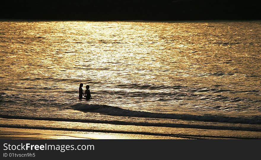 The lover plays with water under the setting sun, matches the golden yellow sea level to appear especially romantically. The lover plays with water under the setting sun, matches the golden yellow sea level to appear especially romantically