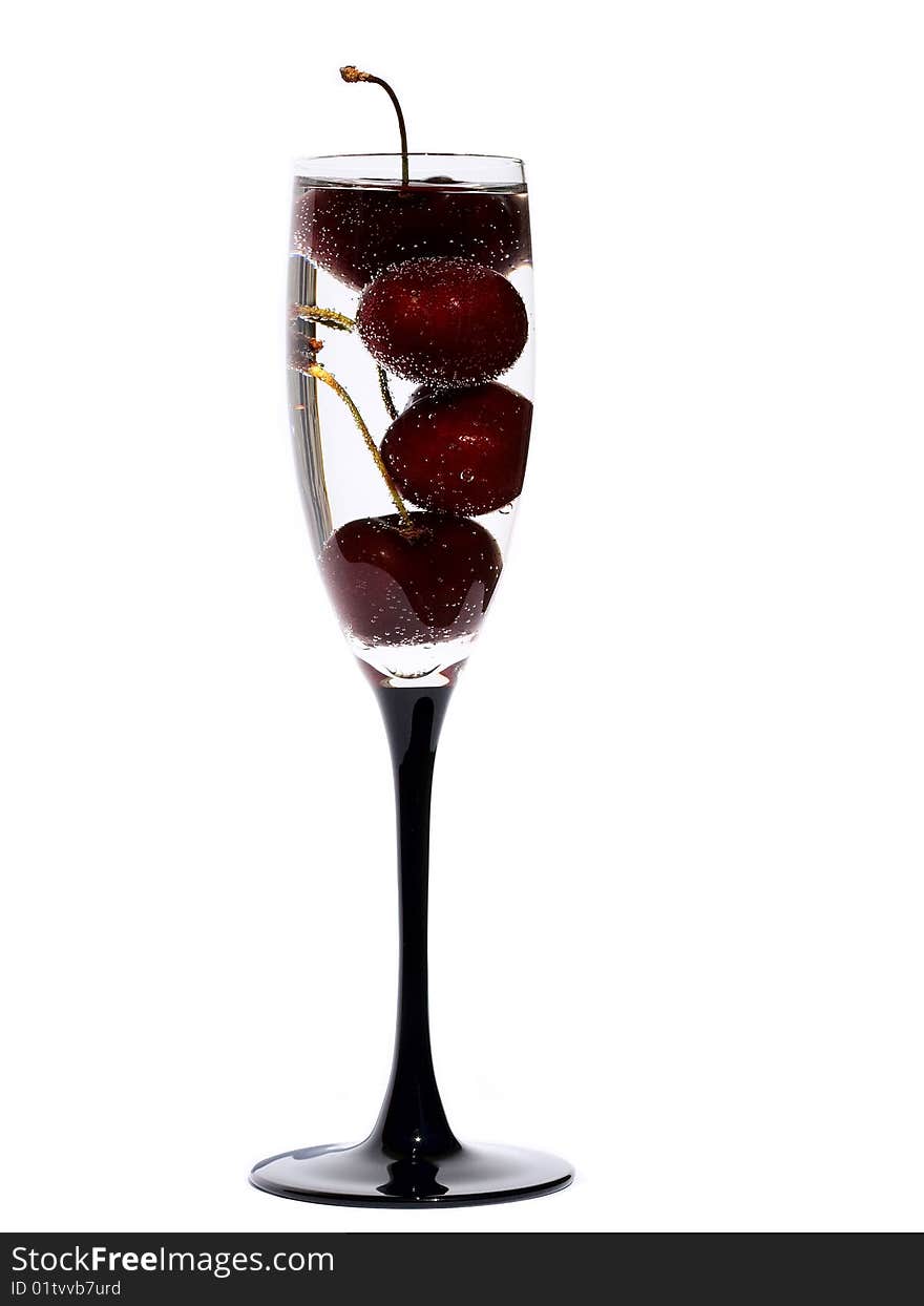 The glass with cherry in water on the white background