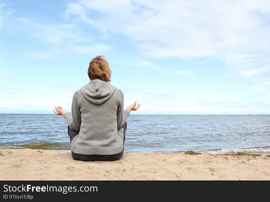 The woman meditates on seacoast. The woman meditates on seacoast