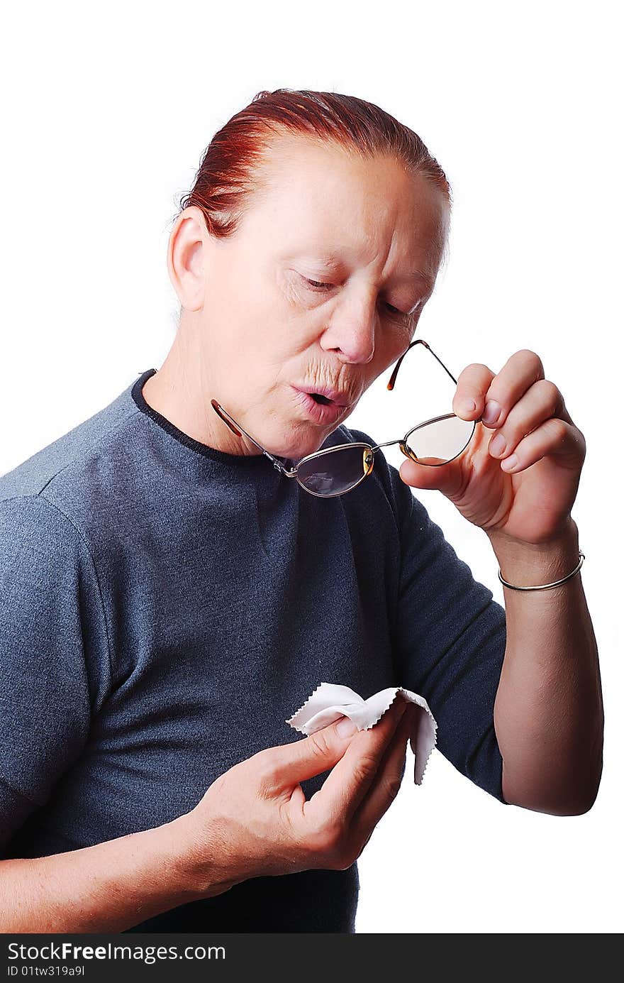 Elderly beautiful woman cleaning her glasses. Elderly beautiful woman cleaning her glasses