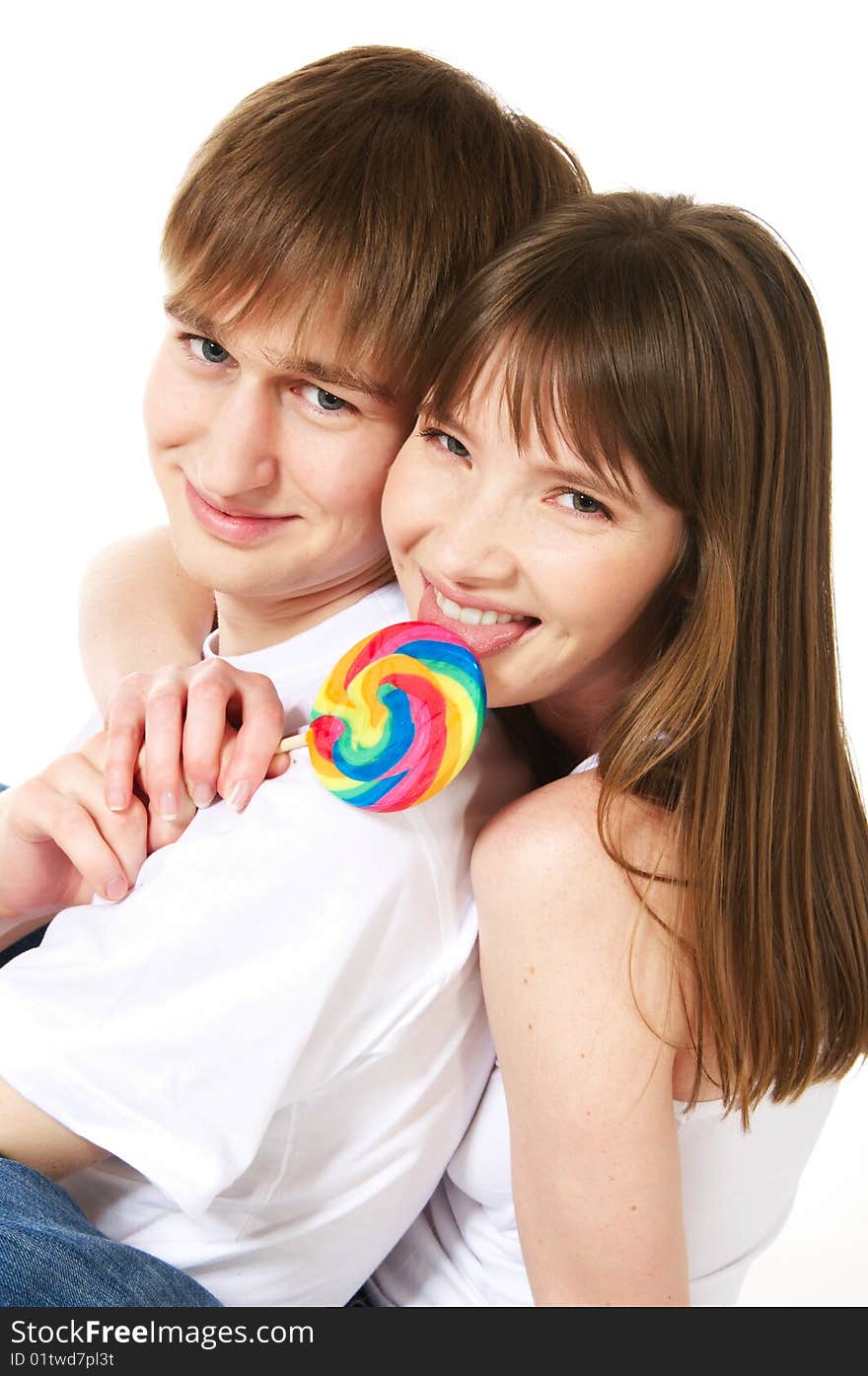 A young teenage couple shares a lollipop