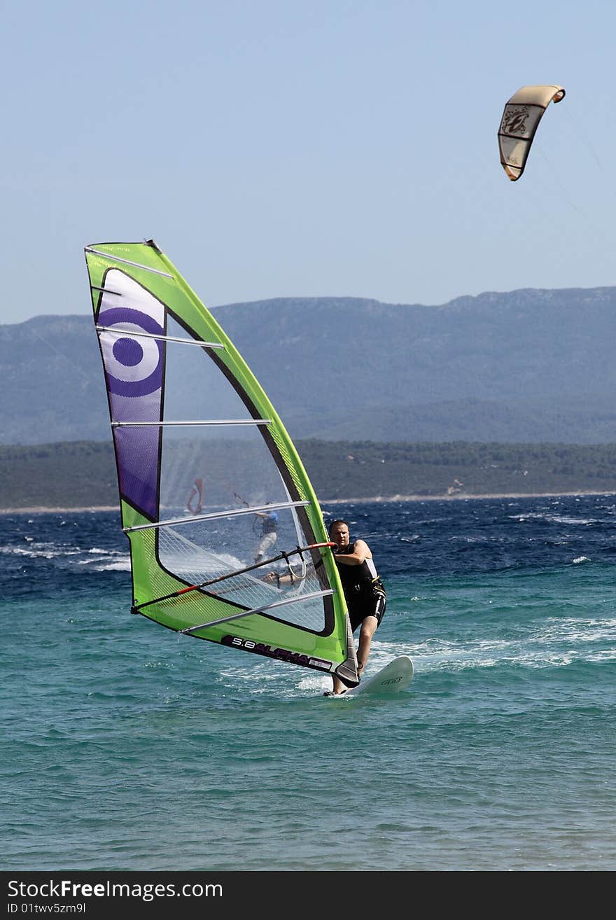 A front picture of a man, surfing @ Zlatni Rat beach, Brac island, Croatia. A front picture of a man, surfing @ Zlatni Rat beach, Brac island, Croatia