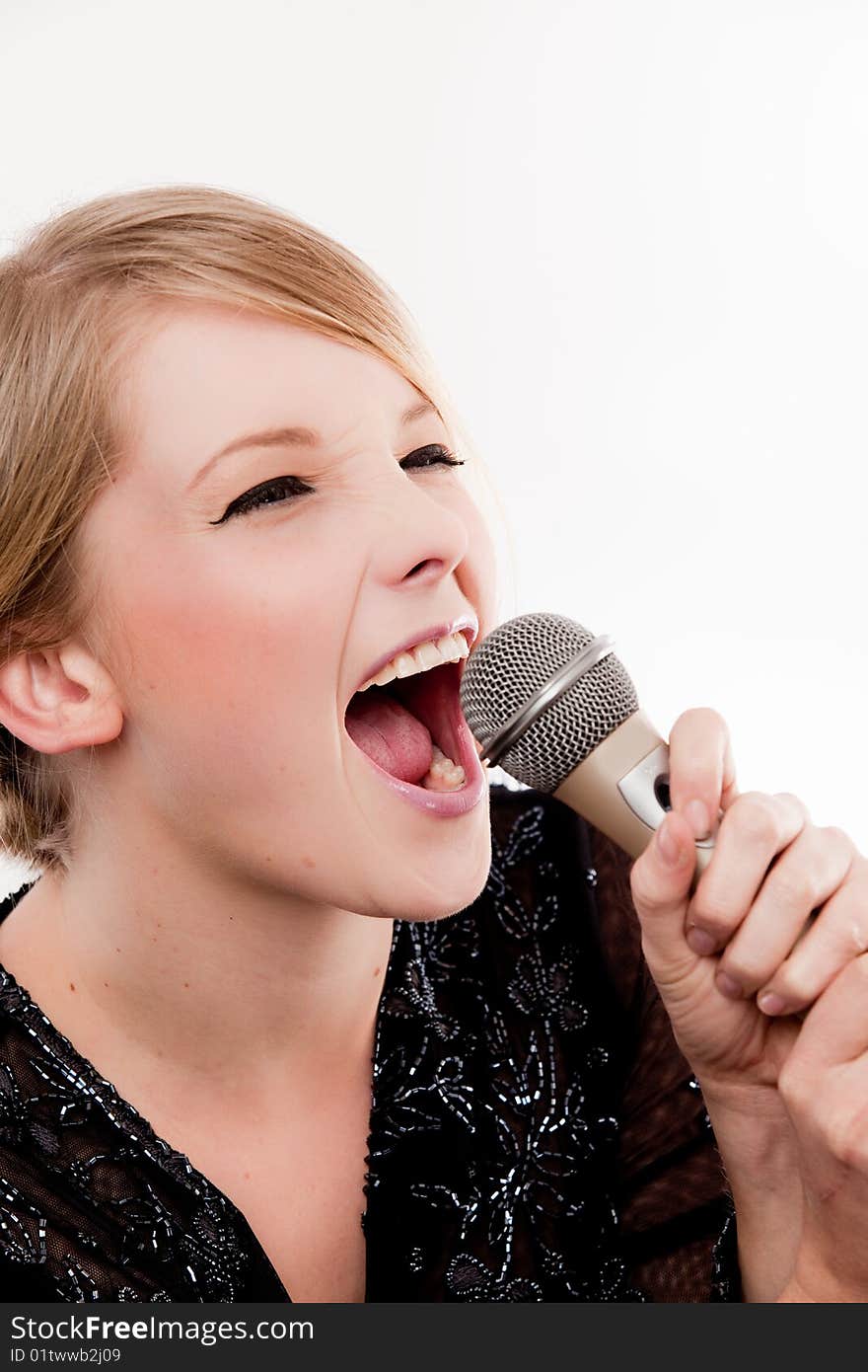 Young fun and bubbly woman sings into microphone with fervour. Young fun and bubbly woman sings into microphone with fervour