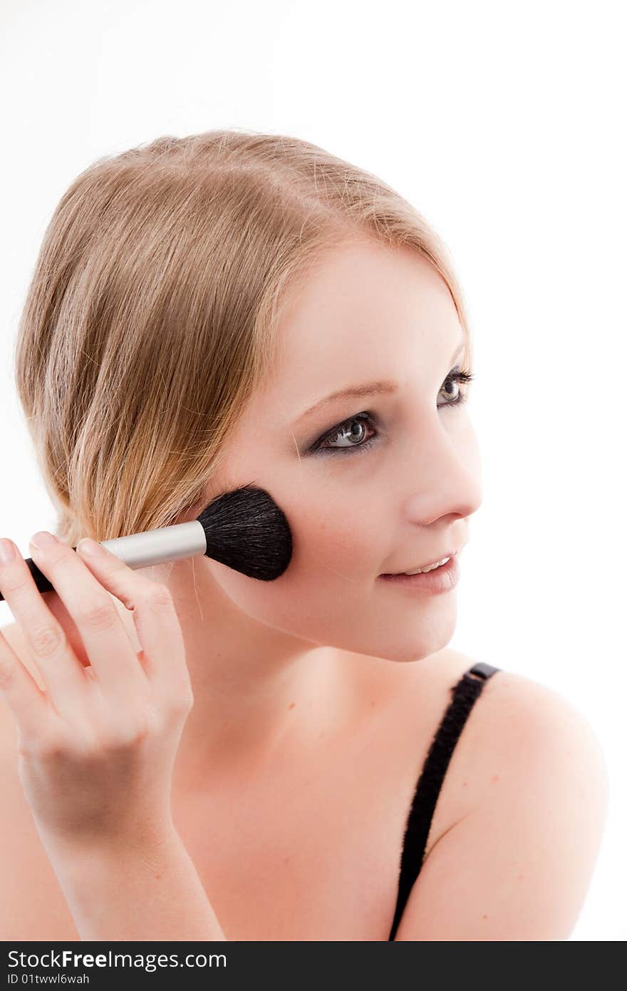 Young woman applies makeup with a soft brush beautiful skin