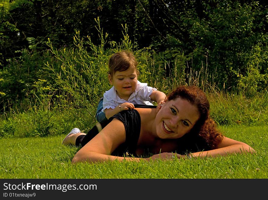 A mother with her daughter lying on top of her. A mother with her daughter lying on top of her.