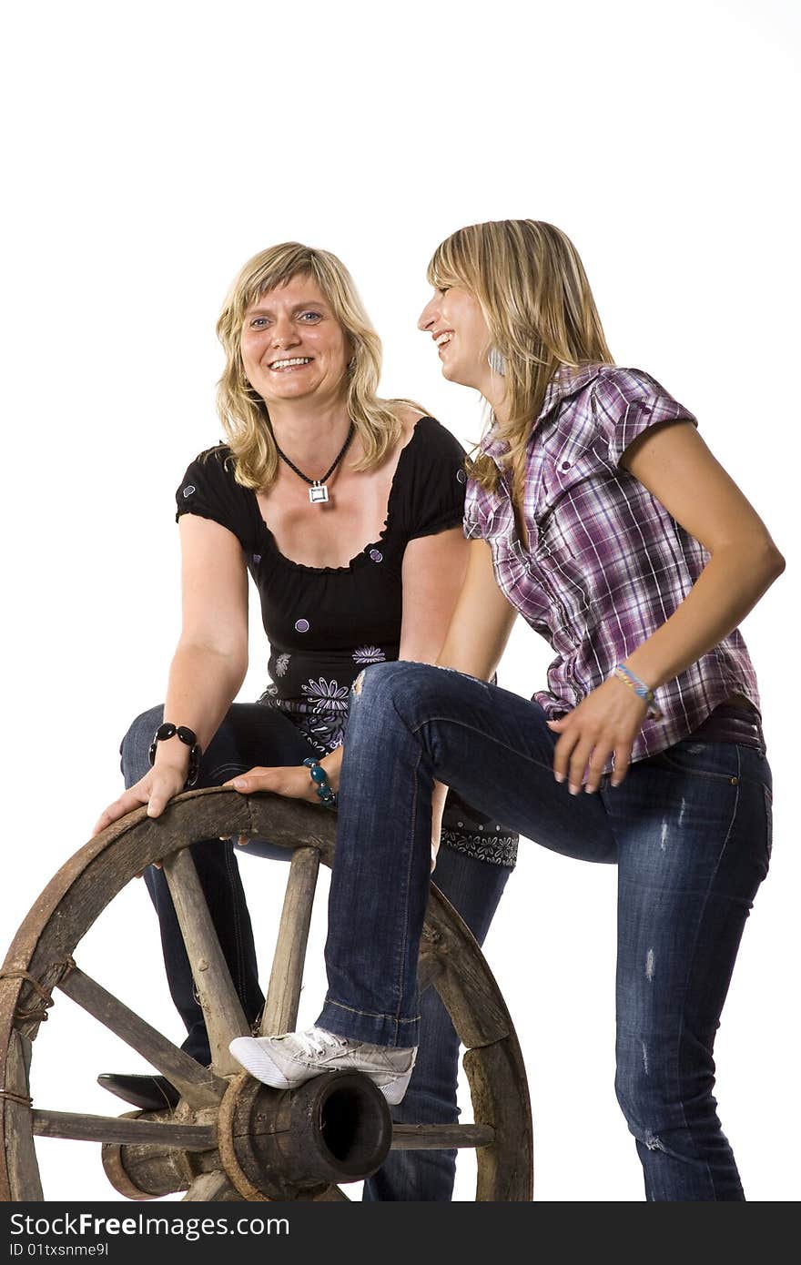 Mother and daughter with old car-wheel