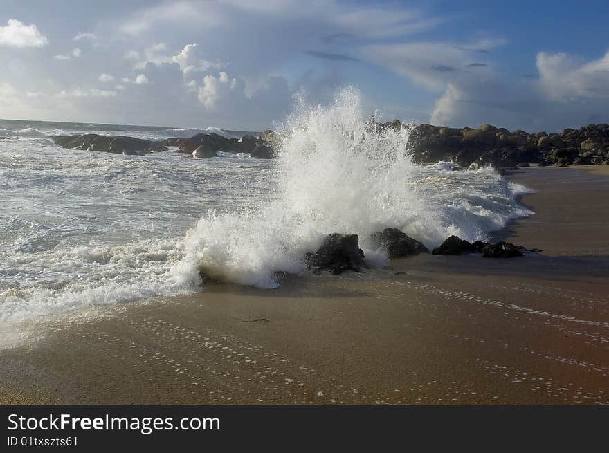 A beautiful beach with waves breaking on the rocks